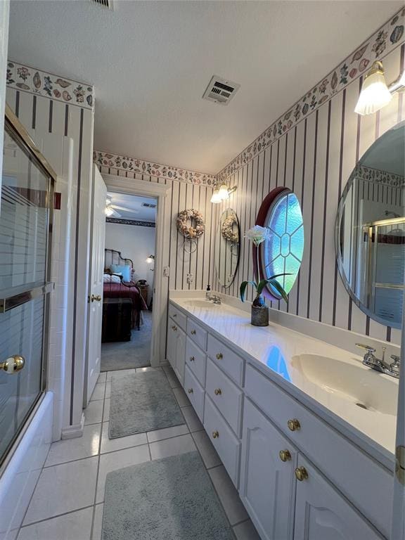 ensuite bathroom featuring ensuite bathroom, a sink, visible vents, double vanity, and wallpapered walls