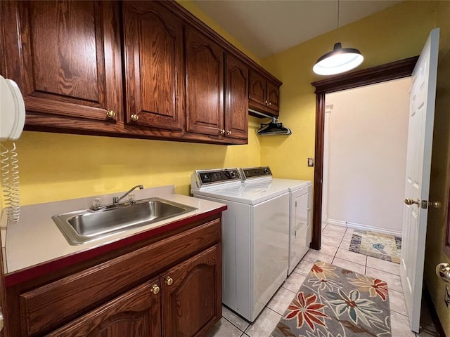 washroom with washing machine and dryer, cabinet space, a sink, and light tile patterned flooring