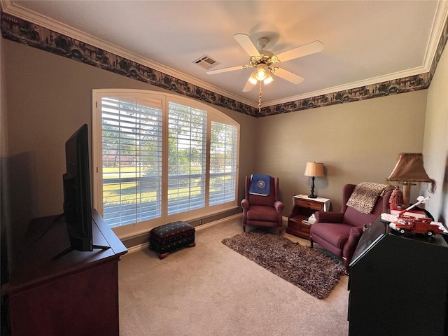 living area with baseboards, visible vents, a ceiling fan, ornamental molding, and carpet