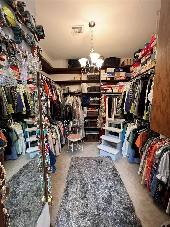 walk in closet with visible vents and a chandelier