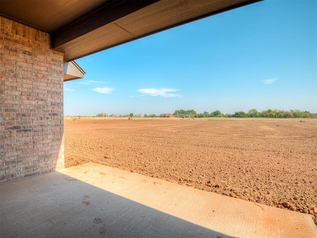 view of yard featuring a rural view and a patio