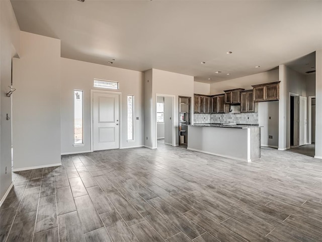 unfurnished living room with baseboards and wood finished floors