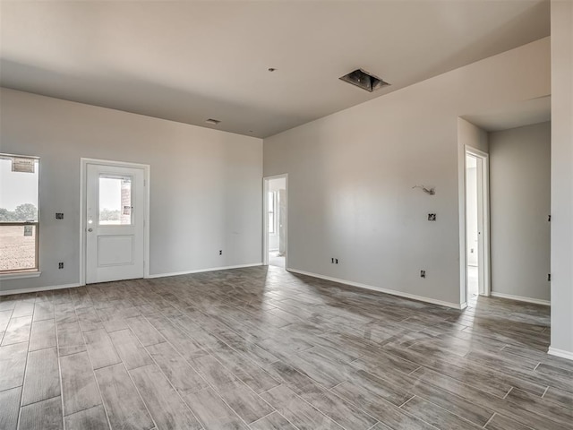 unfurnished living room with baseboards and wood finished floors