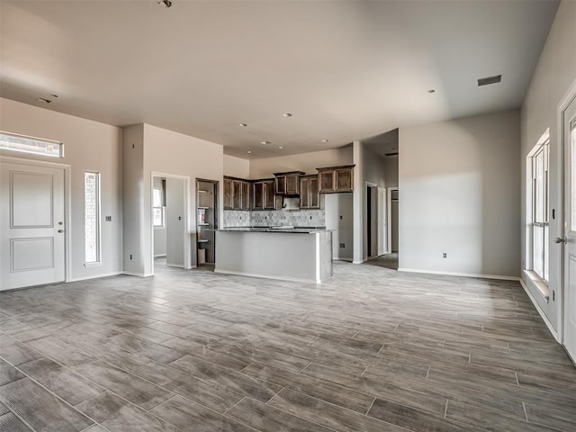 unfurnished living room featuring baseboards and wood finish floors