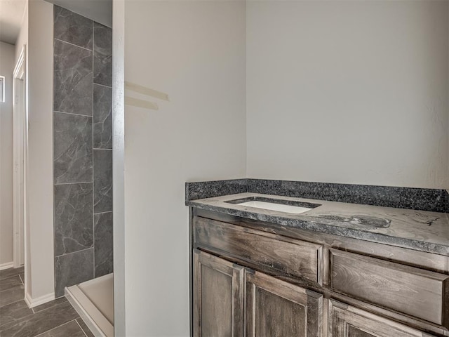 bathroom with vanity, baseboards, and a shower stall