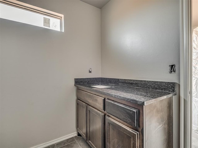 bathroom with baseboards, tile patterned floors, and vanity