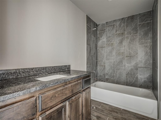 bathroom featuring vanity, wood finished floors, and shower / tub combination