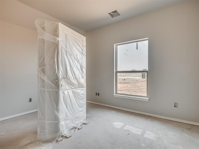 unfurnished room with baseboards