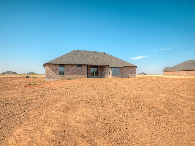 rear view of house featuring brick siding