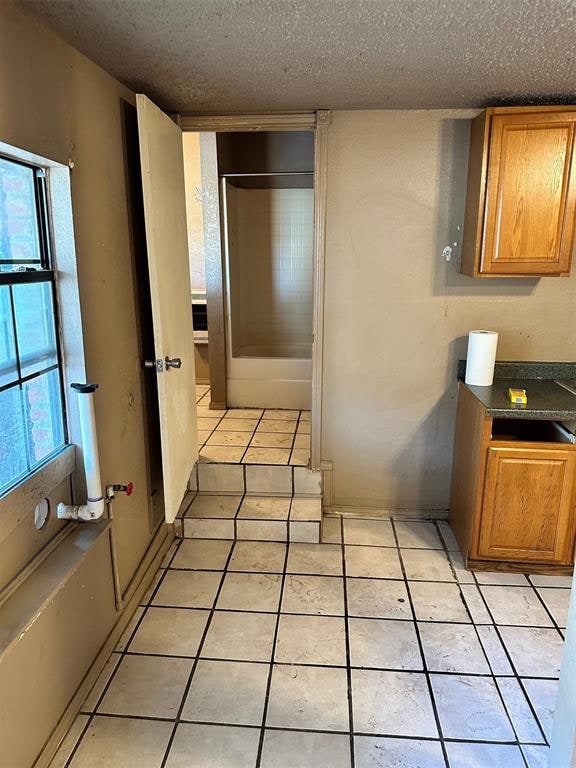 kitchen featuring light tile patterned flooring and a textured ceiling