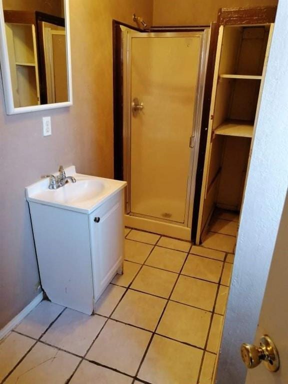 bathroom with tile patterned flooring, vanity, and a shower with shower door