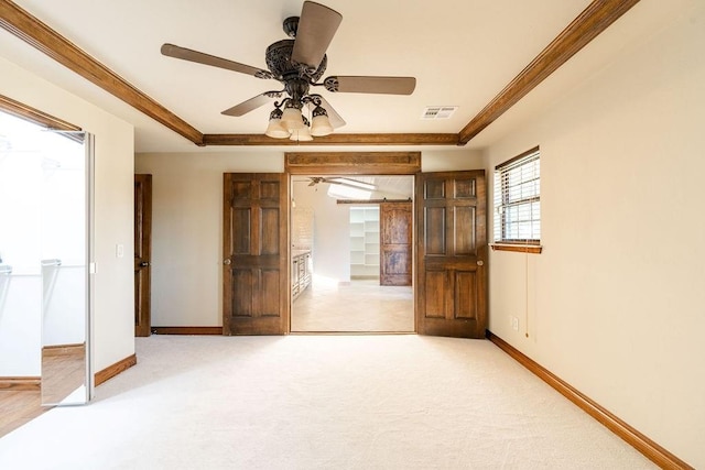 unfurnished bedroom featuring light carpet, crown molding, and ceiling fan