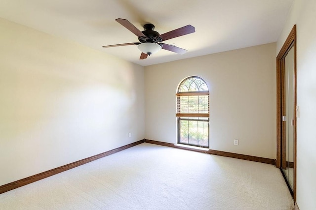 empty room featuring ceiling fan and light colored carpet