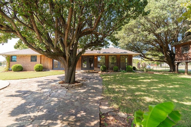 single story home featuring french doors and a front lawn