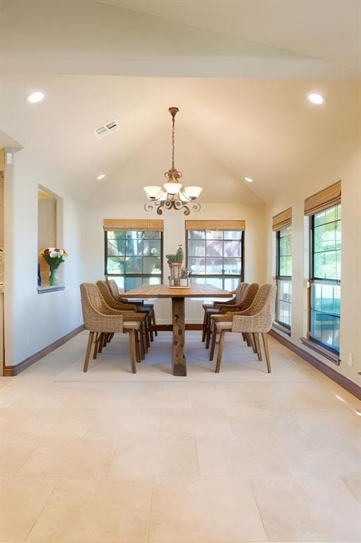 tiled dining space with an inviting chandelier and vaulted ceiling