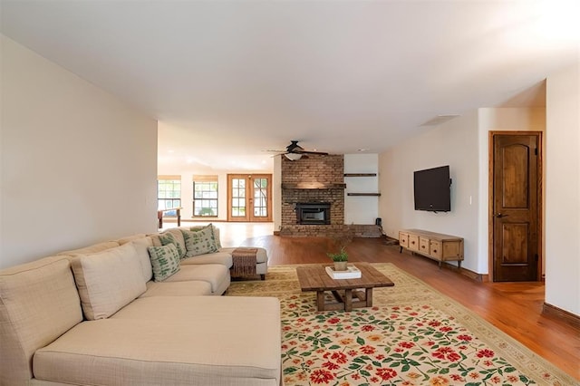 living room featuring a fireplace, ceiling fan, and hardwood / wood-style floors