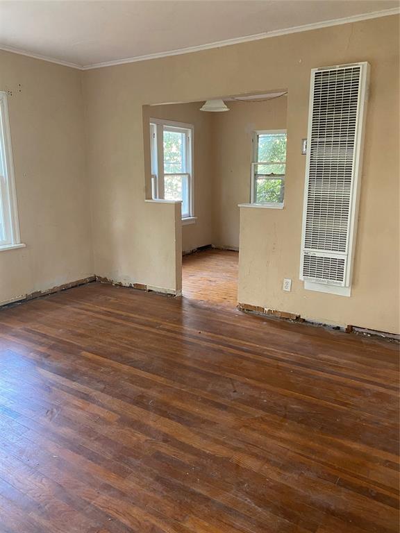 spare room with dark wood-type flooring and ornamental molding