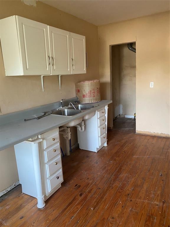 kitchen featuring sink, white cabinetry, and dark wood-type flooring