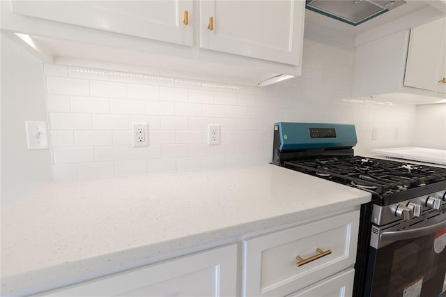 kitchen with tasteful backsplash, white cabinetry, and stainless steel range with gas stovetop