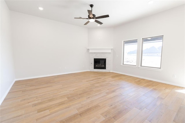 unfurnished living room featuring light hardwood / wood-style flooring, a fireplace, and ceiling fan