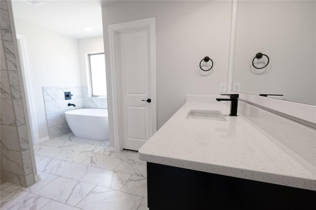 bathroom featuring vanity and a bath