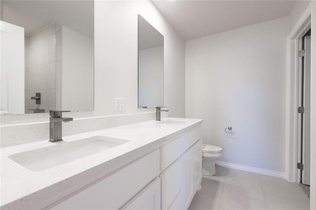 bathroom with tile patterned floors, toilet, double vanity, and a sink