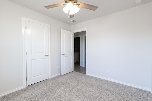 unfurnished bedroom featuring baseboards, visible vents, a ceiling fan, and light colored carpet