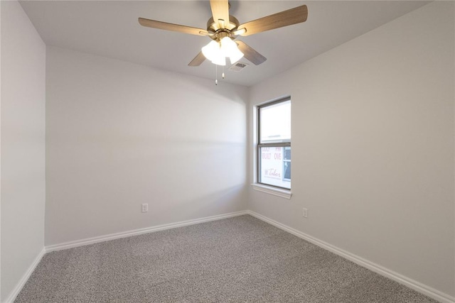 carpeted spare room with baseboards, visible vents, and a ceiling fan