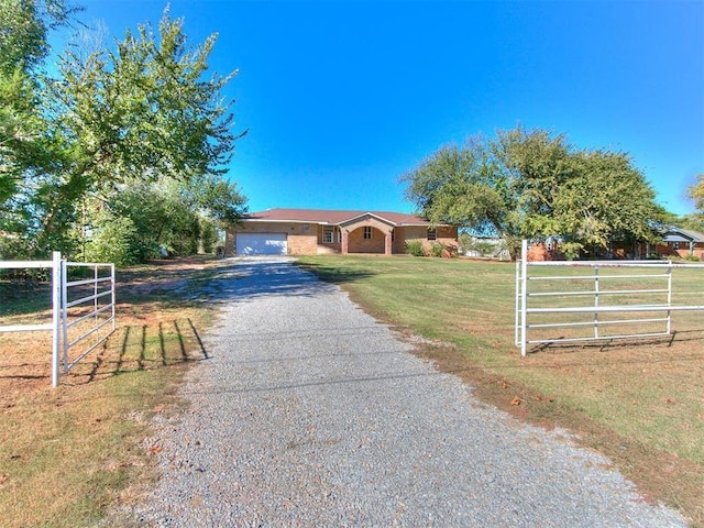 view of front of home with a rural view, a garage, and a front lawn