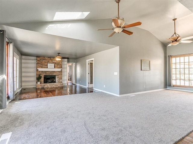 unfurnished living room featuring lofted ceiling with skylight, a fireplace, and dark wood-type flooring