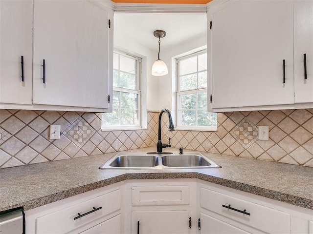 kitchen featuring decorative light fixtures, white cabinetry, and sink