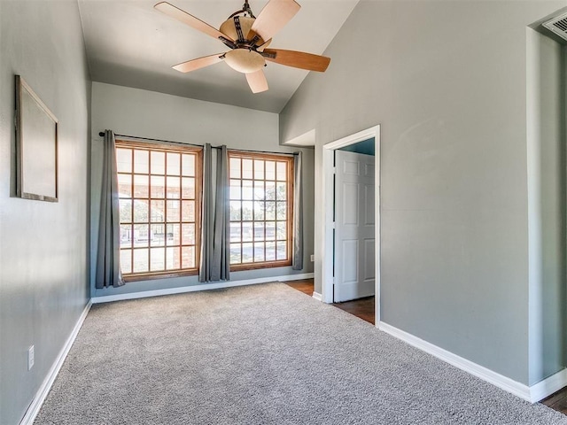 unfurnished room with ceiling fan, dark carpet, and high vaulted ceiling