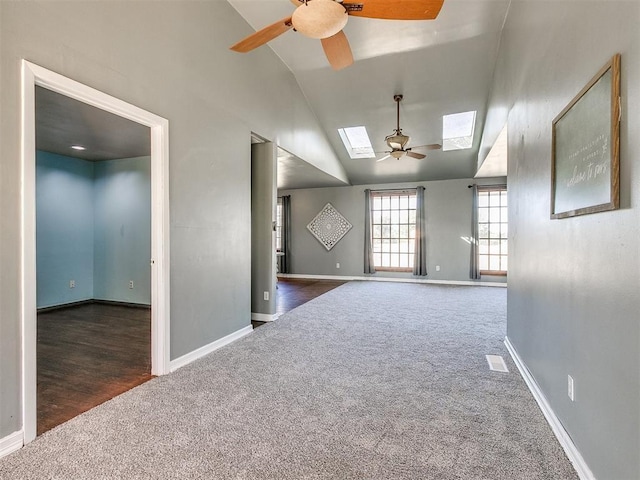 spare room with dark hardwood / wood-style flooring, lofted ceiling with skylight, and ceiling fan