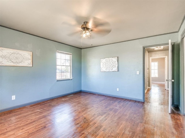 spare room featuring a wealth of natural light, ceiling fan, and hardwood / wood-style flooring