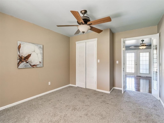 unfurnished bedroom featuring carpet flooring, french doors, a closet, and ceiling fan