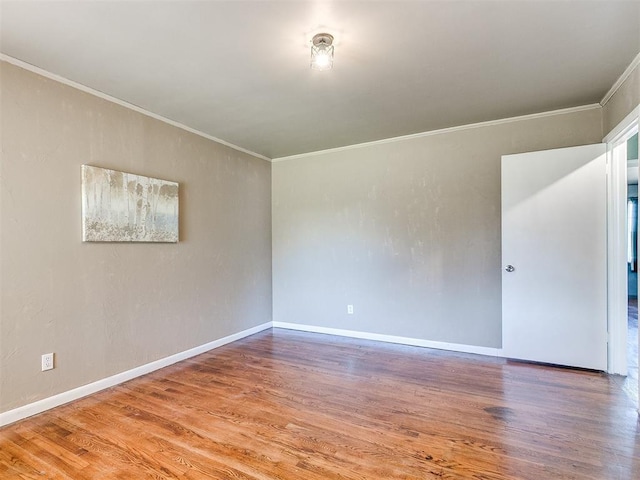 spare room featuring wood-type flooring and crown molding