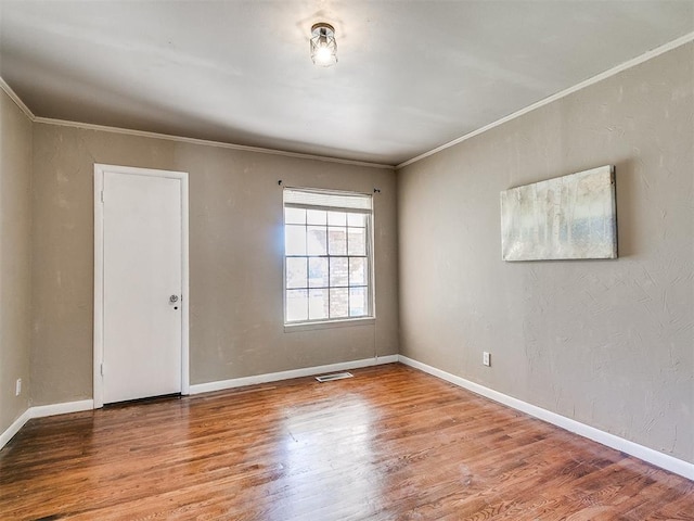 unfurnished room with hardwood / wood-style flooring and ornamental molding