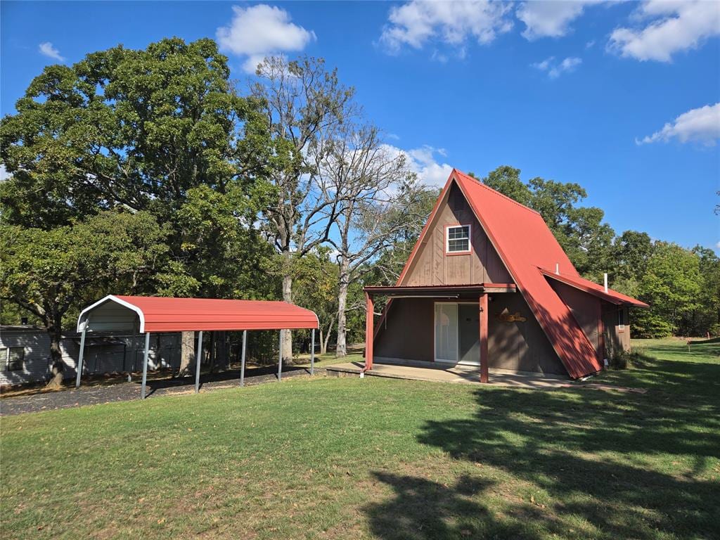 view of outdoor structure featuring a lawn and a carport