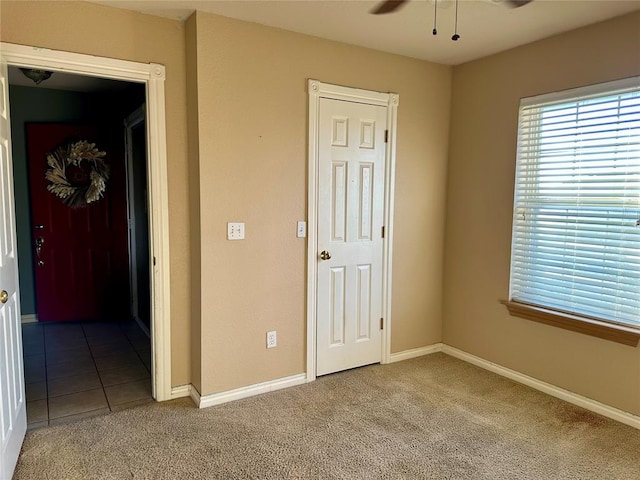 unfurnished bedroom featuring ceiling fan and carpet floors