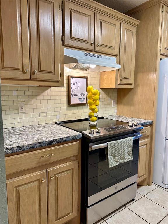 kitchen with stainless steel range with electric cooktop, crown molding, decorative backsplash, fridge, and light tile patterned flooring