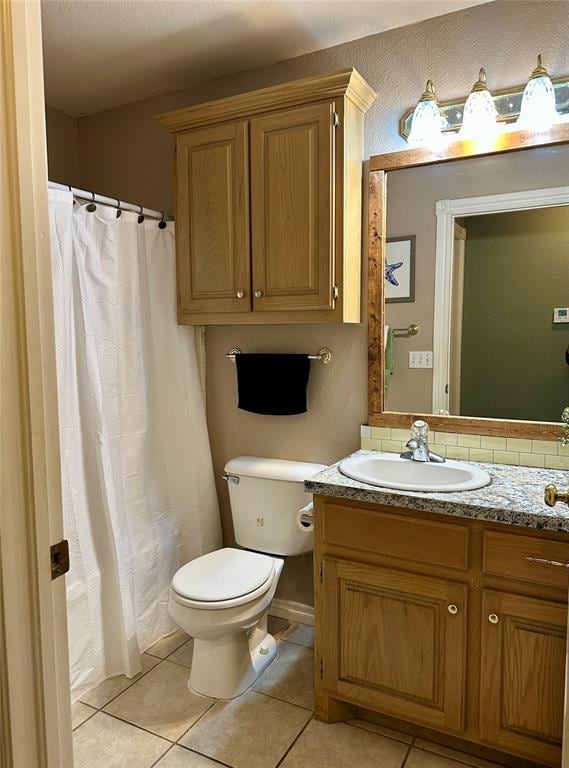 bathroom featuring tile patterned flooring, vanity, and toilet