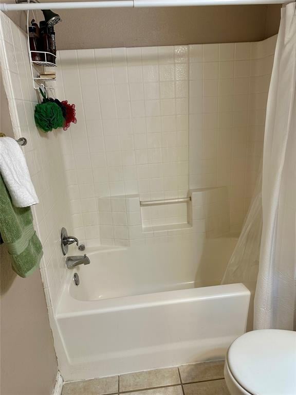 bathroom featuring tile patterned floors, shower / bath combo with shower curtain, and toilet