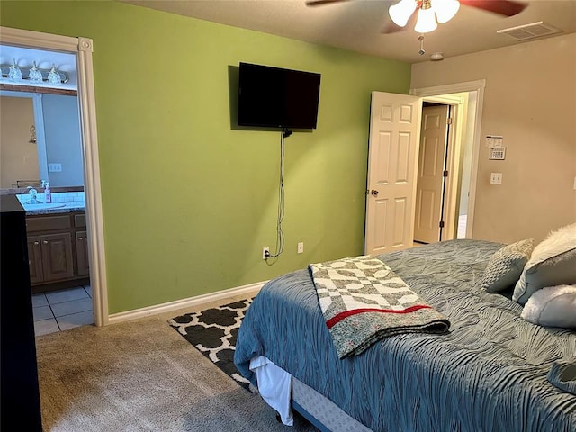 carpeted bedroom featuring ceiling fan, sink, and ensuite bath