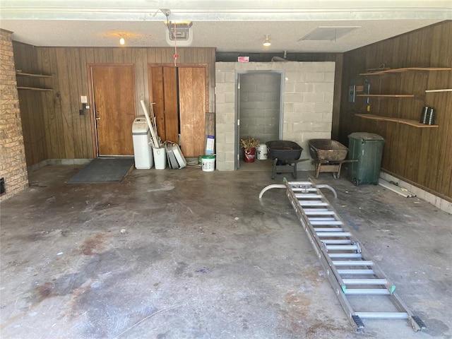 garage with a garage door opener and wooden walls