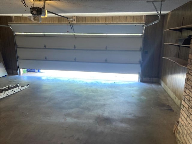 garage with wood walls and a garage door opener