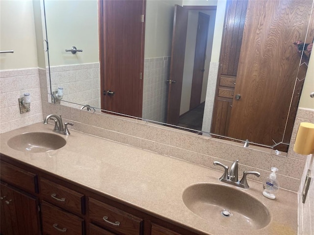 bathroom with vanity and tile walls