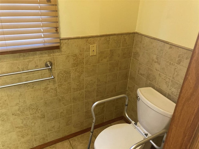 bathroom featuring tile patterned floors, toilet, and tile walls