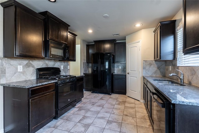 kitchen with black appliances, decorative backsplash, stone countertops, and sink