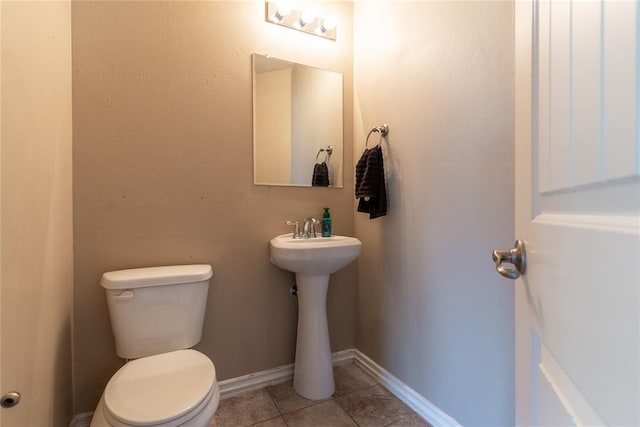 bathroom with tile patterned flooring, toilet, and sink