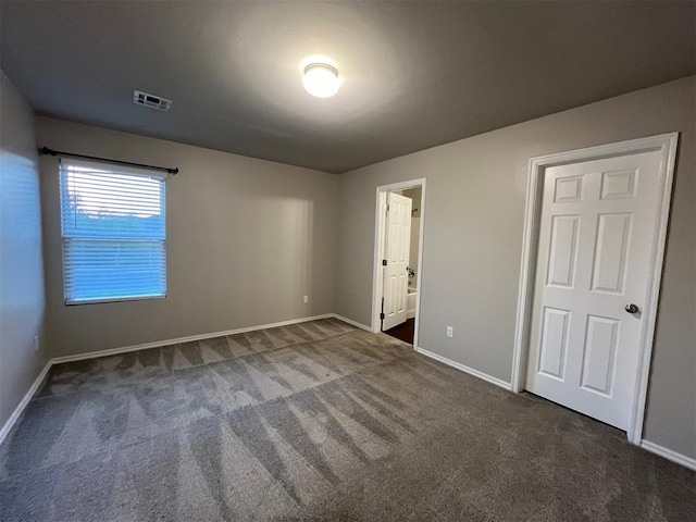 unfurnished bedroom with dark colored carpet